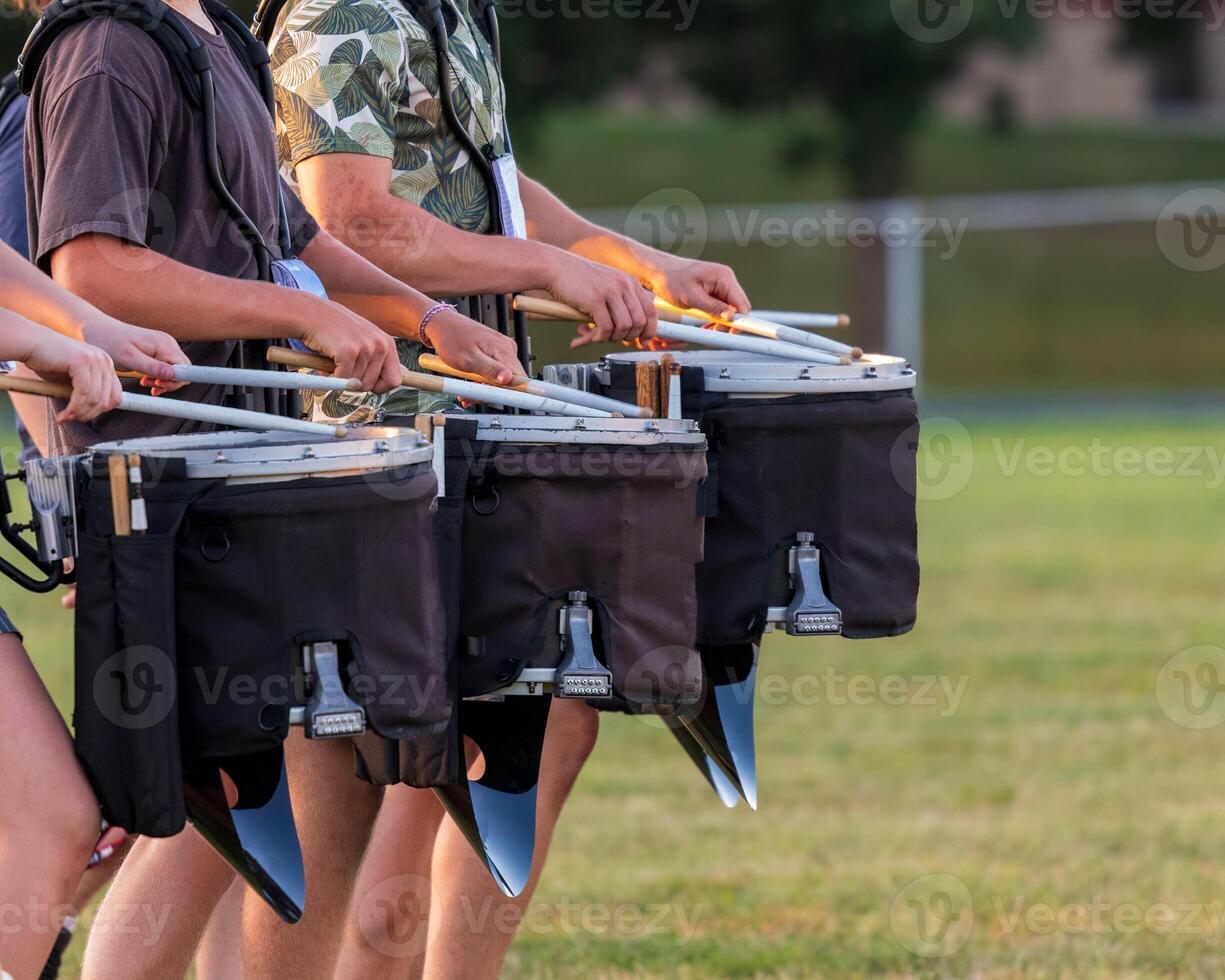 a section of a marching band drum line rehearsing photo