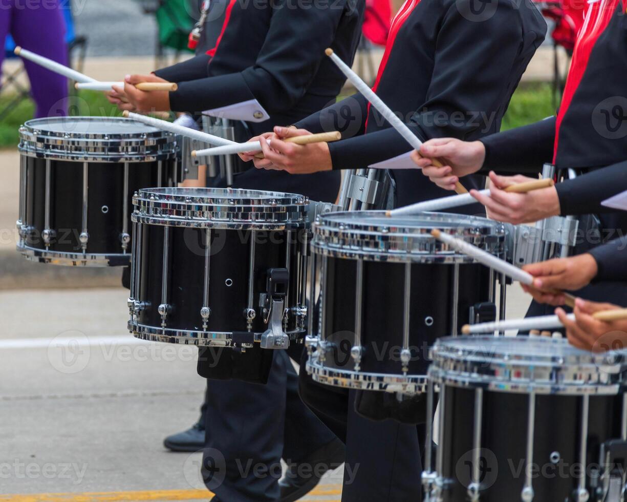 bass section of a marching band drum line warming up for a parade photo