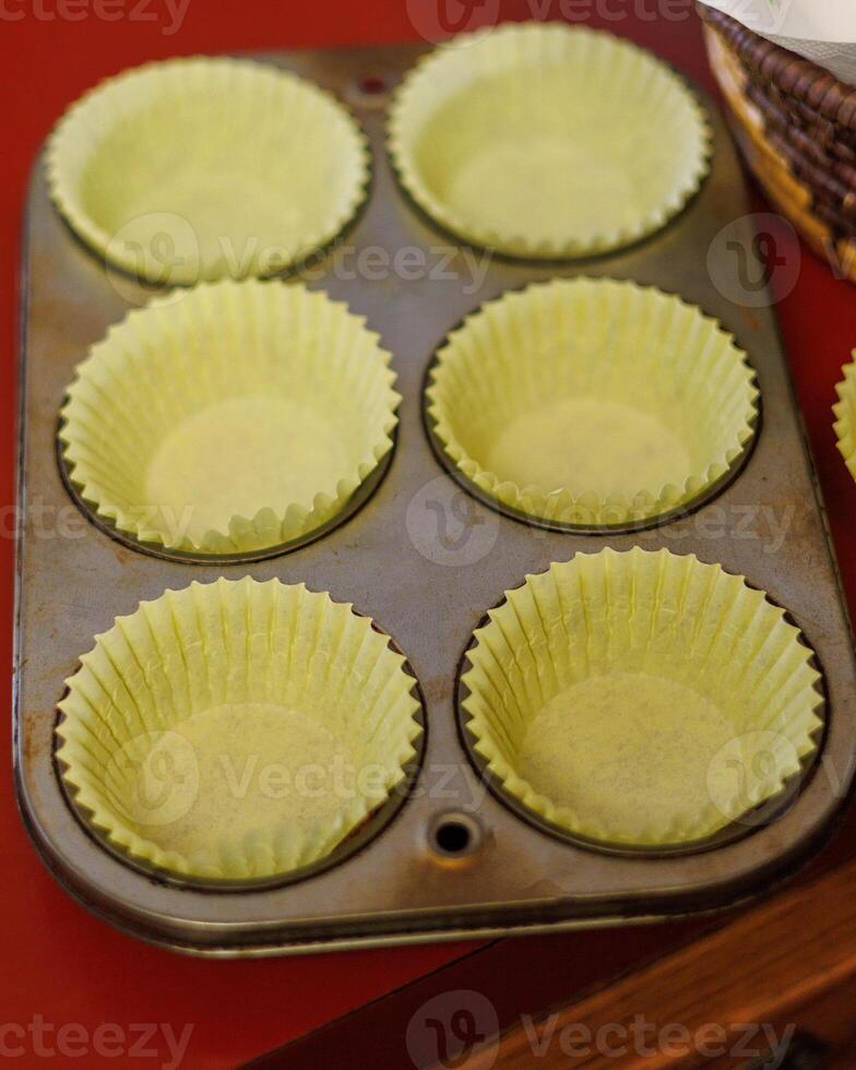 a tray of cupcake papers waiting for vegetarian cornbread batter to be spooned in photo