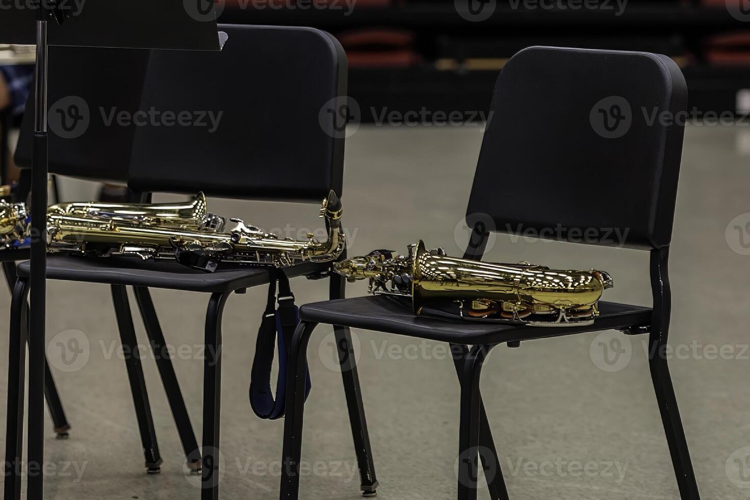 two alto saxophones resting on chairs at a band camp rehearsal photo