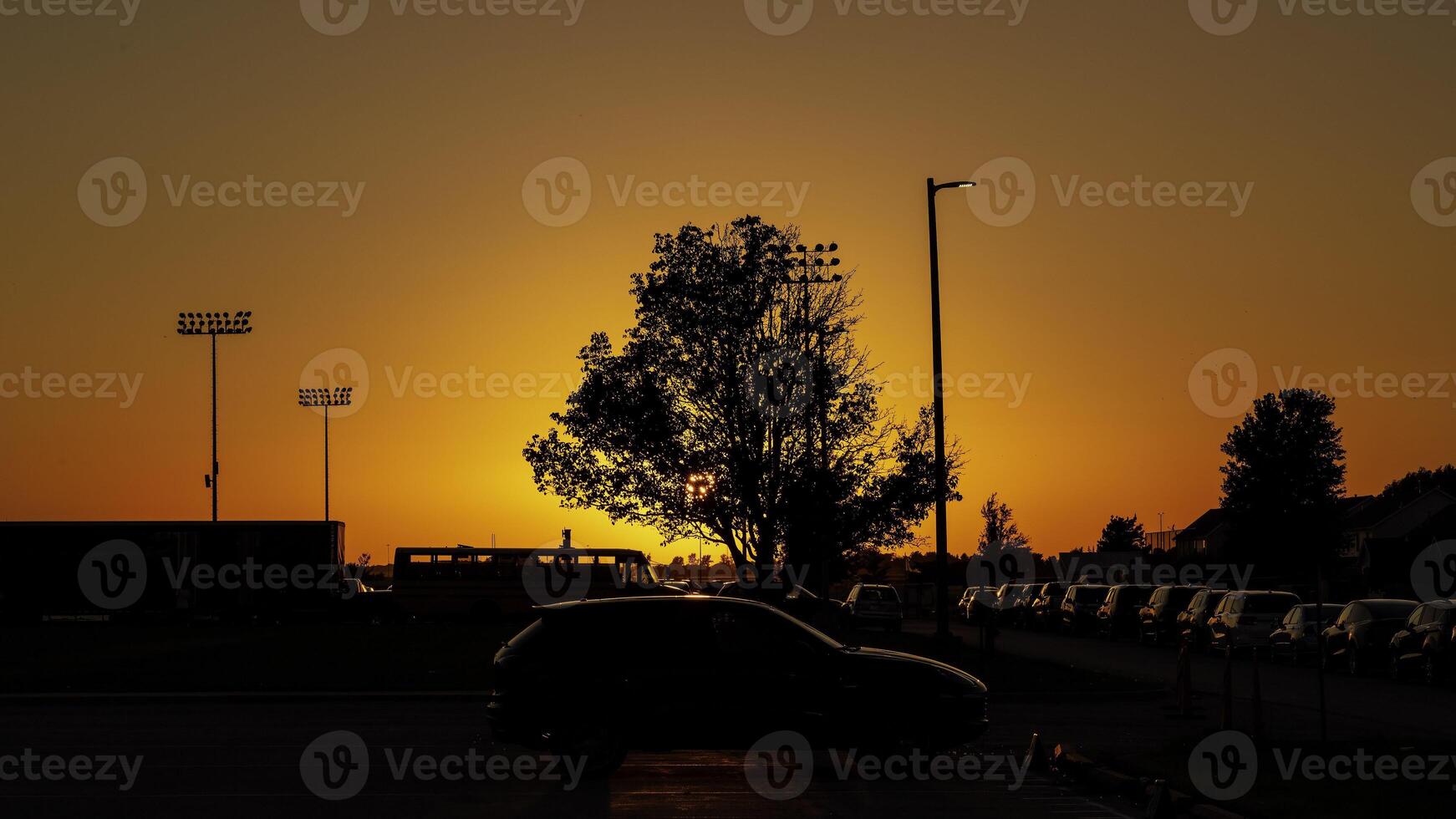 an orange sunset of the athletic fields and a soccer game in progress photo