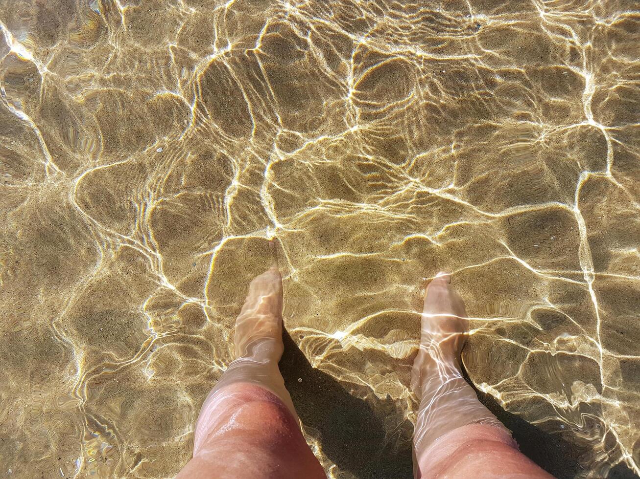 with your feet in the sea water photo