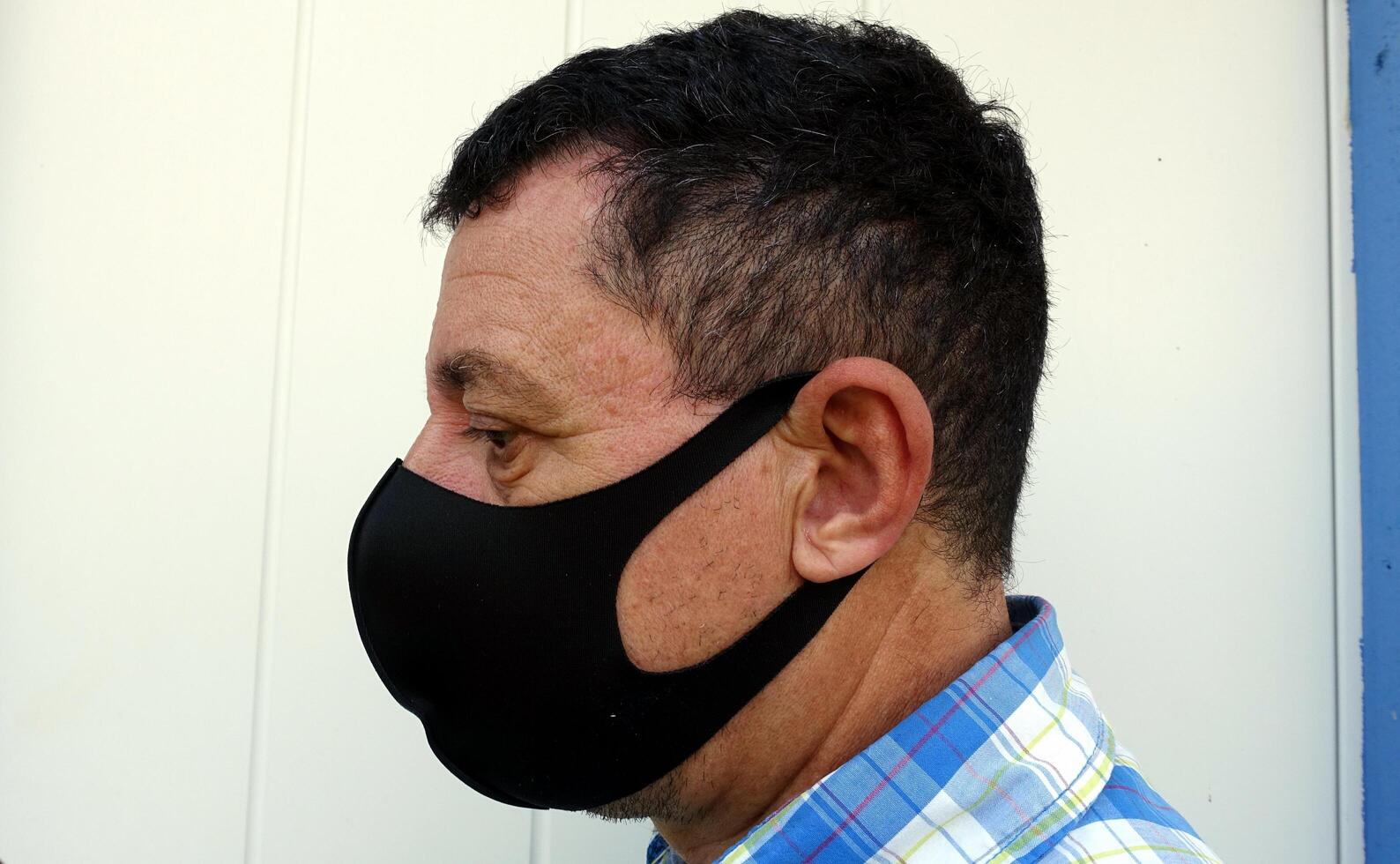 image depicting the face of a man with a black protective anti-contagion mask photo