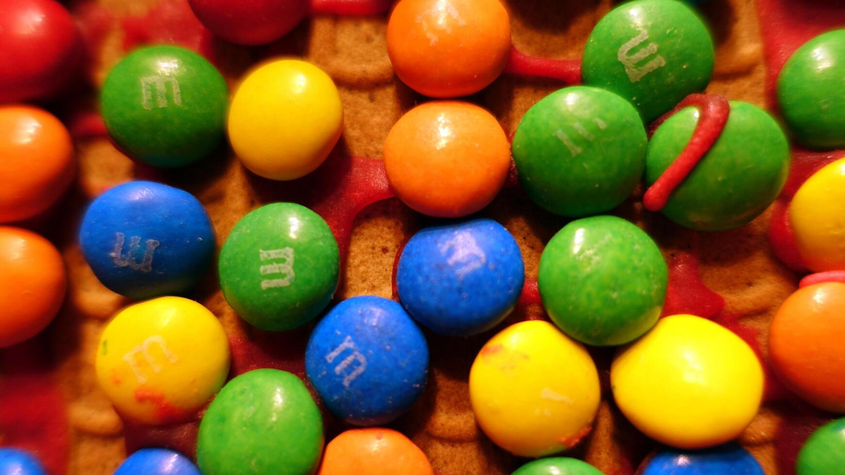 Small colorful chocolates on the roof of a homemade gingerbread house photo