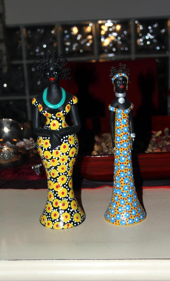 two small statues of African women with colorful clothes photo