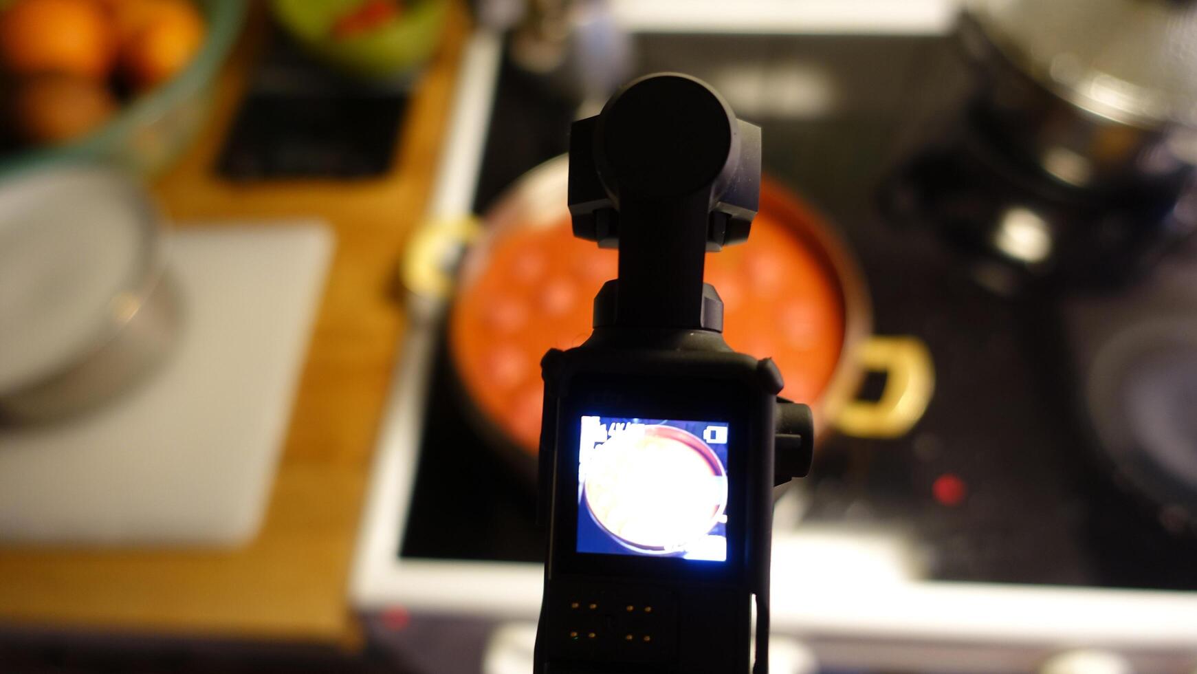 A digital camera is filming homemade meatballs simmering in tomato sauce photo