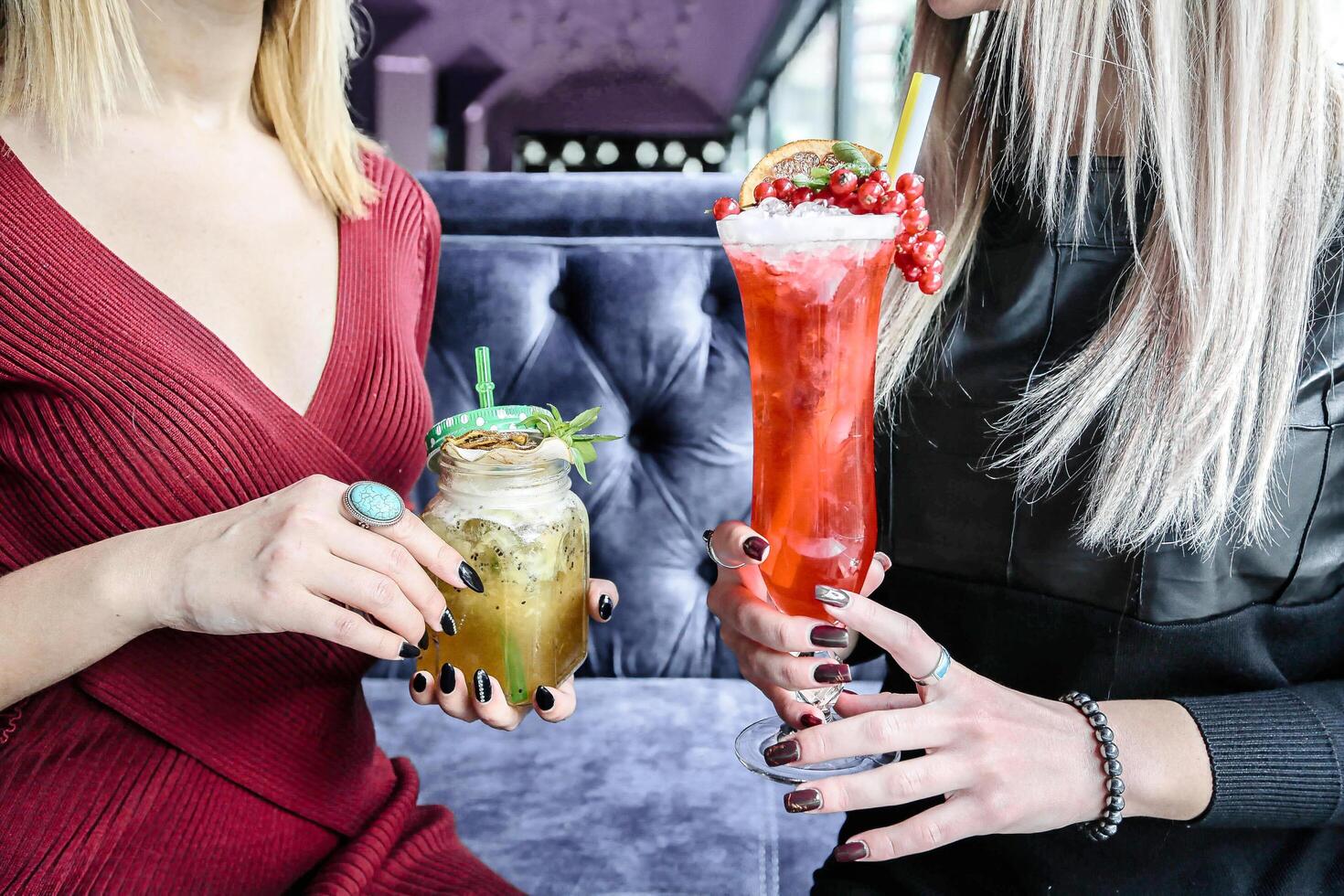 Two Women Holding Drinks at a Cafe Table photo