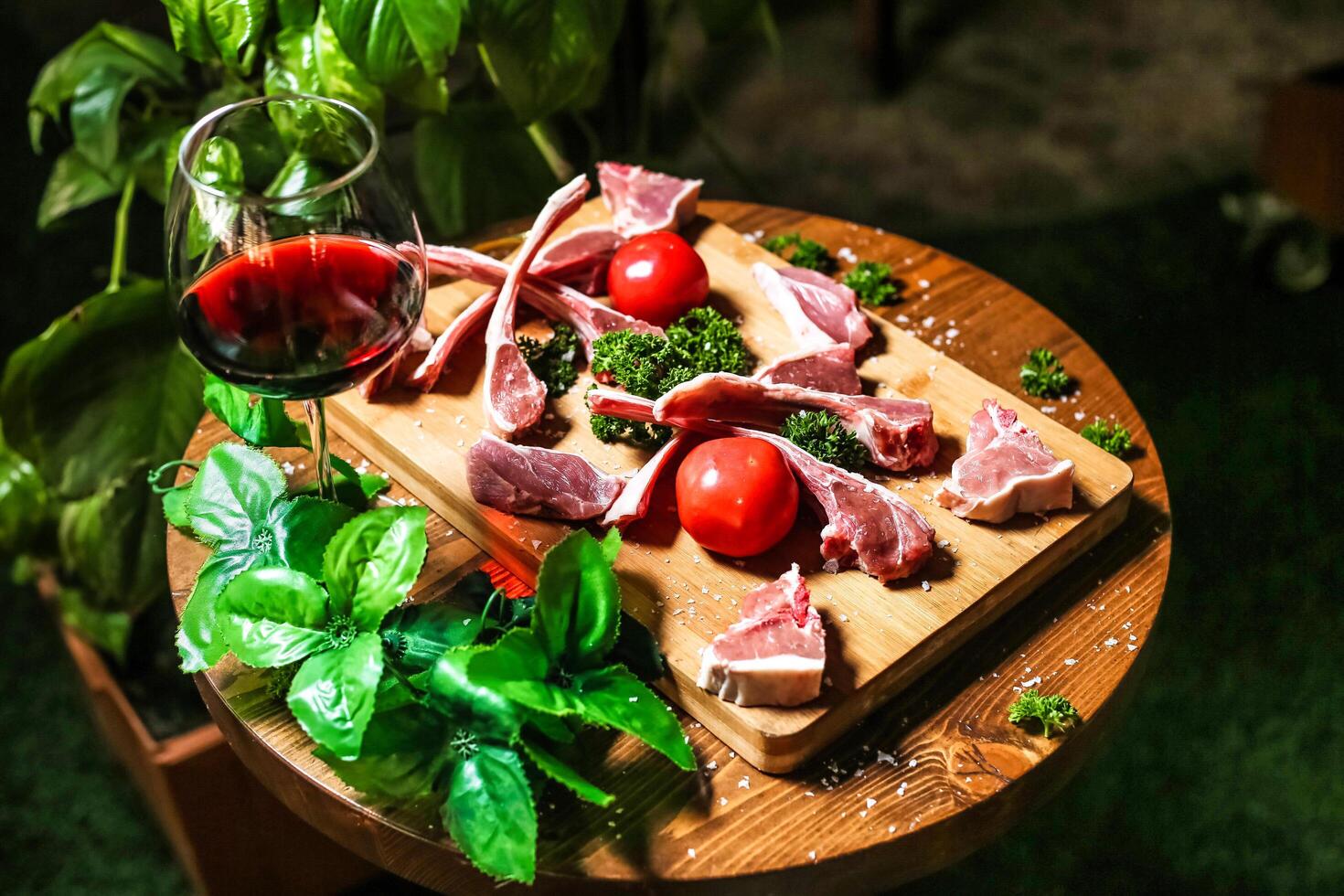 Cutting Board With Meat and Veggies Next to Glass of Wine photo