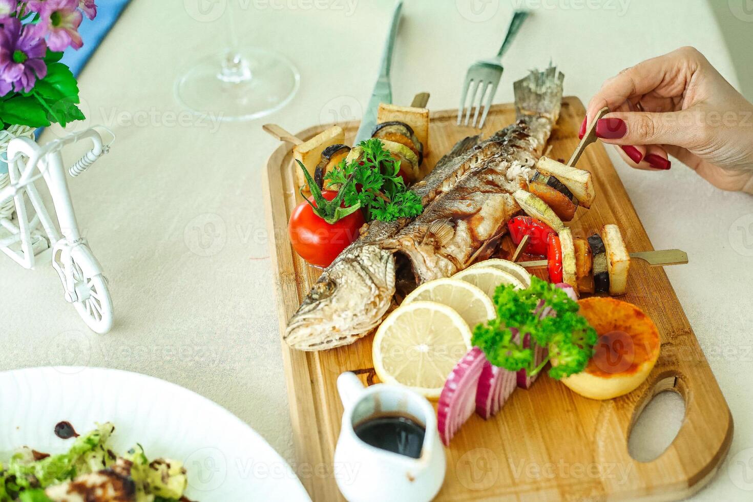 Person Cutting Up Fish on Cutting Board photo