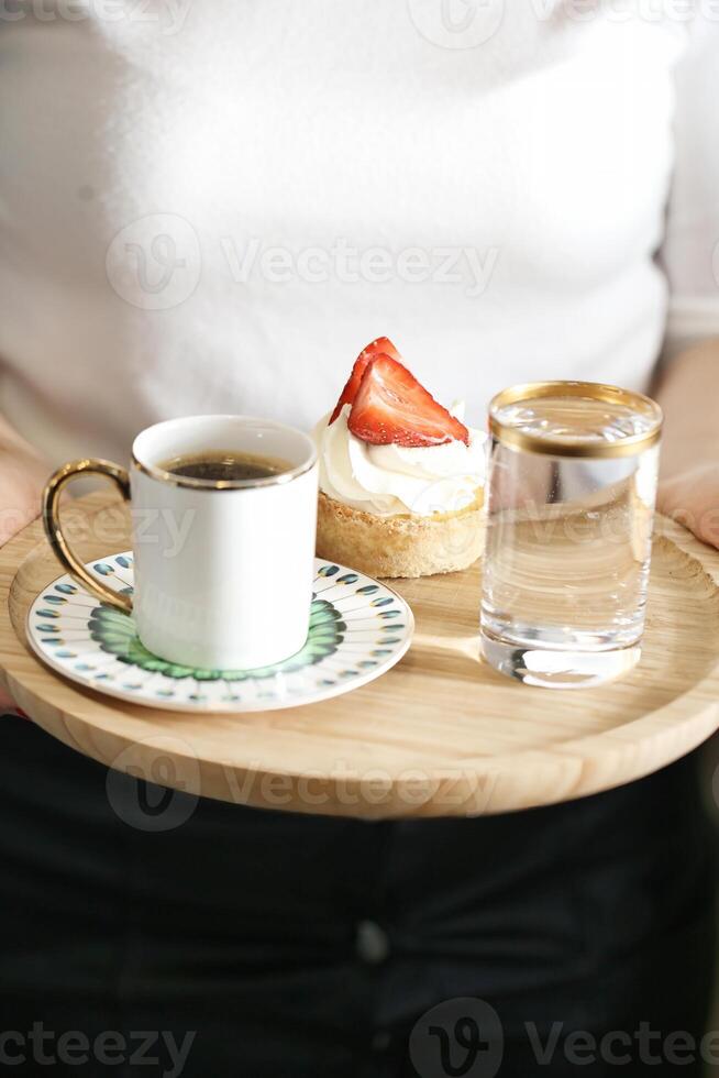 Person Holding Tray With Coffee Cup and Pastry photo