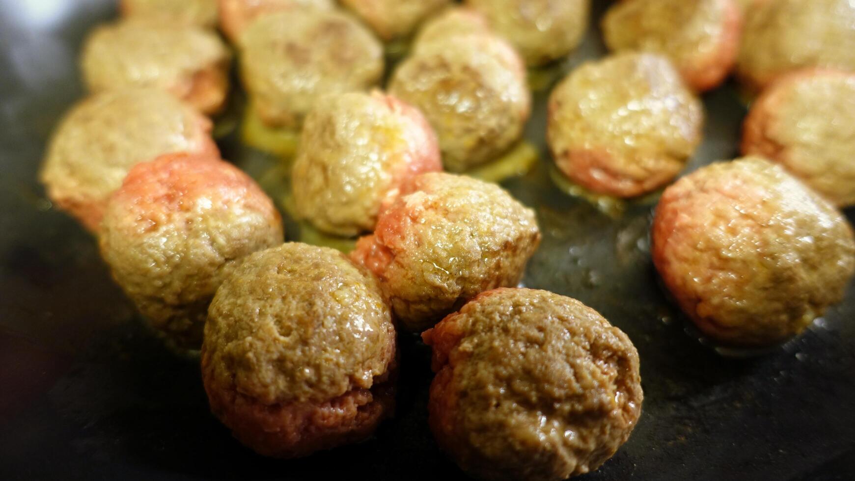 Homemade meatballs are cooking in the pan photo