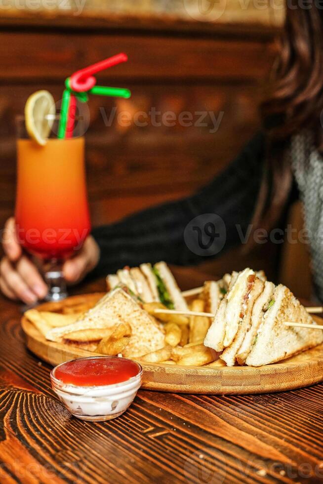 persona sentado a mesa con plato de comida y bebida foto