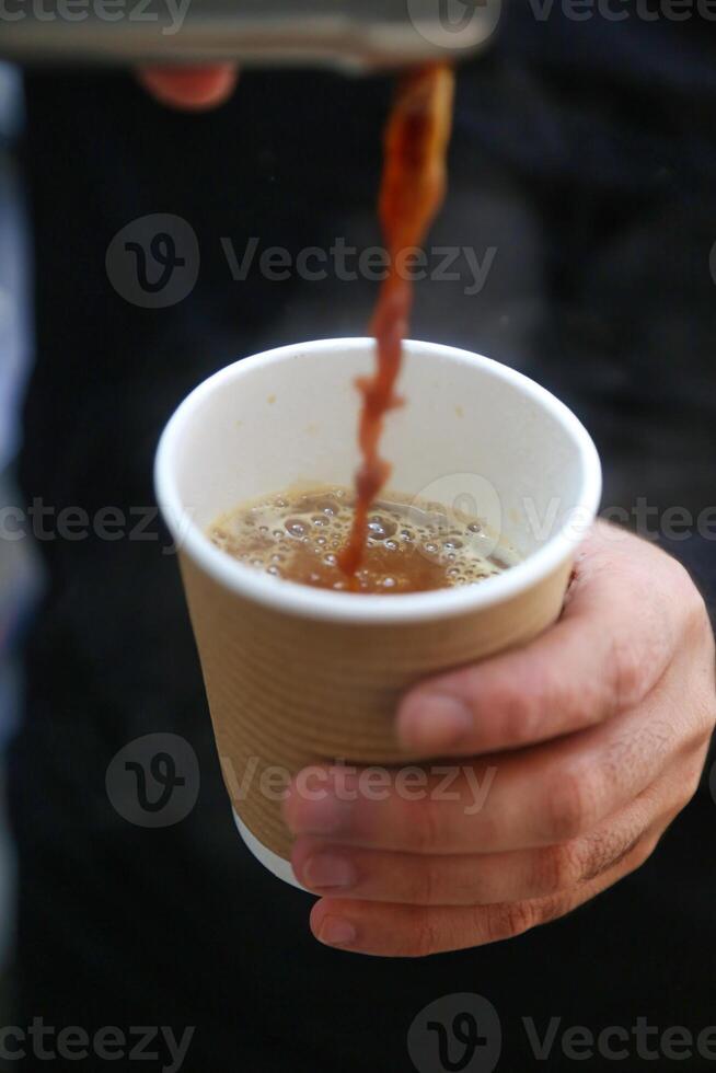 Person Holding a Cup of Coffee in a Caf photo