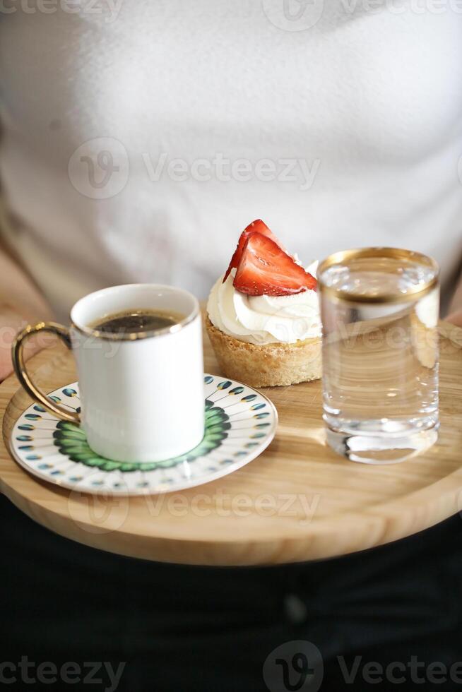 Person Holding Plate With Coffee Cup and Strawberry photo