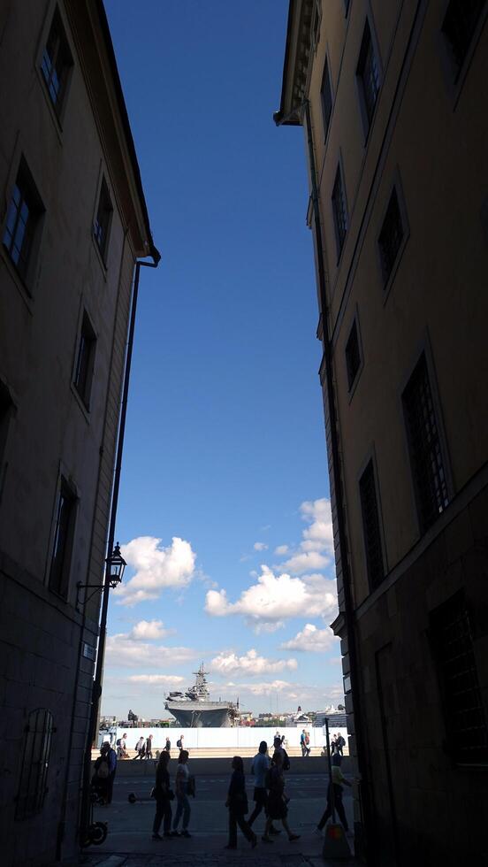 Stockholm, Sweden, June 4, 2022 A warship in the bay can be seen from a small street photo