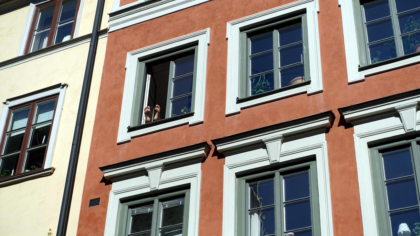dos pies arriba surgir desde un ventana en el histórico centro. foto