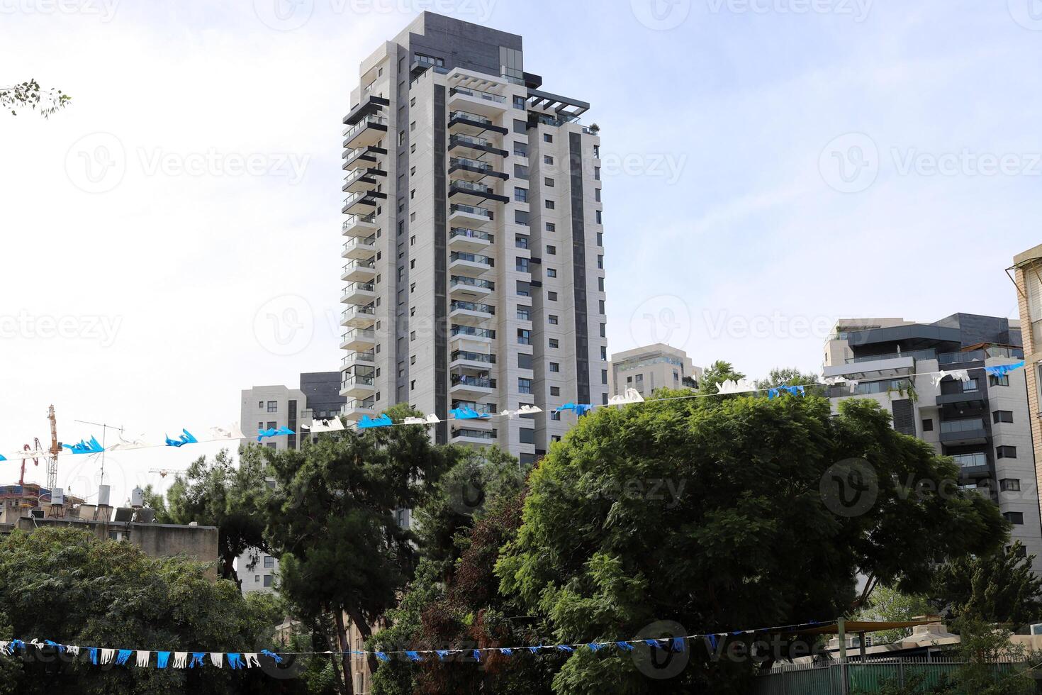 Tel Aviv Israel 03 28 2024. Buildings and structures in Tel Aviv through the foliage of tall trees. photo