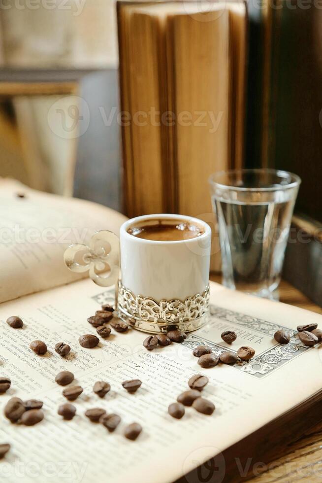 Cup of Coffee Resting on Open Book photo