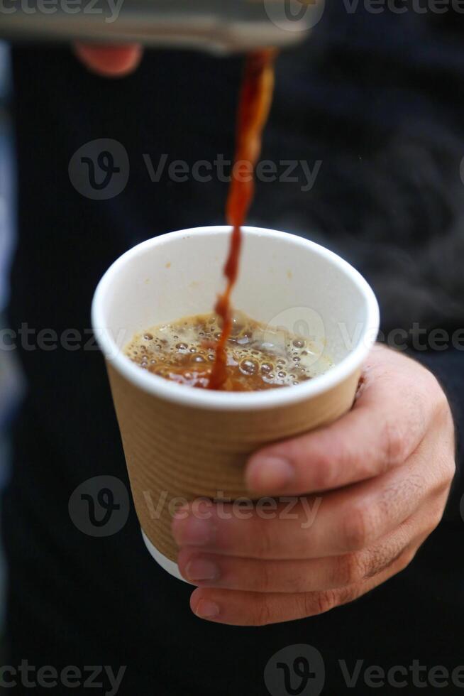 Person Pouring Hot Coffee Into a White Ceramic Cup photo