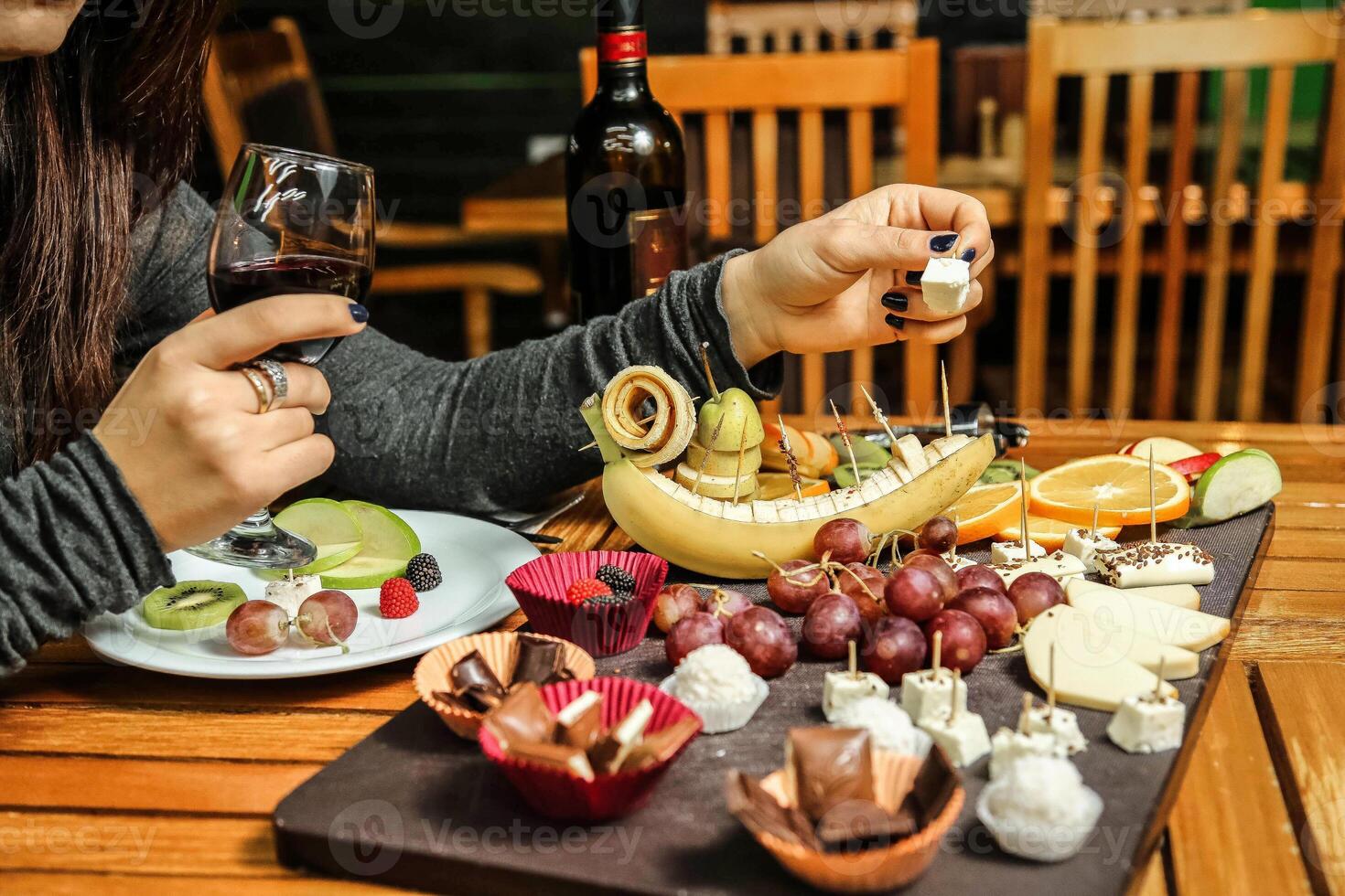 mujer sentado a mesa con plato de comida y vaso de vino foto