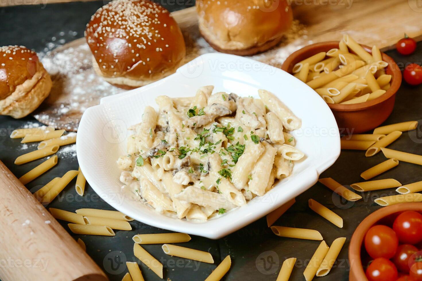 Plate of Pasta With Roll and Tomatoes photo