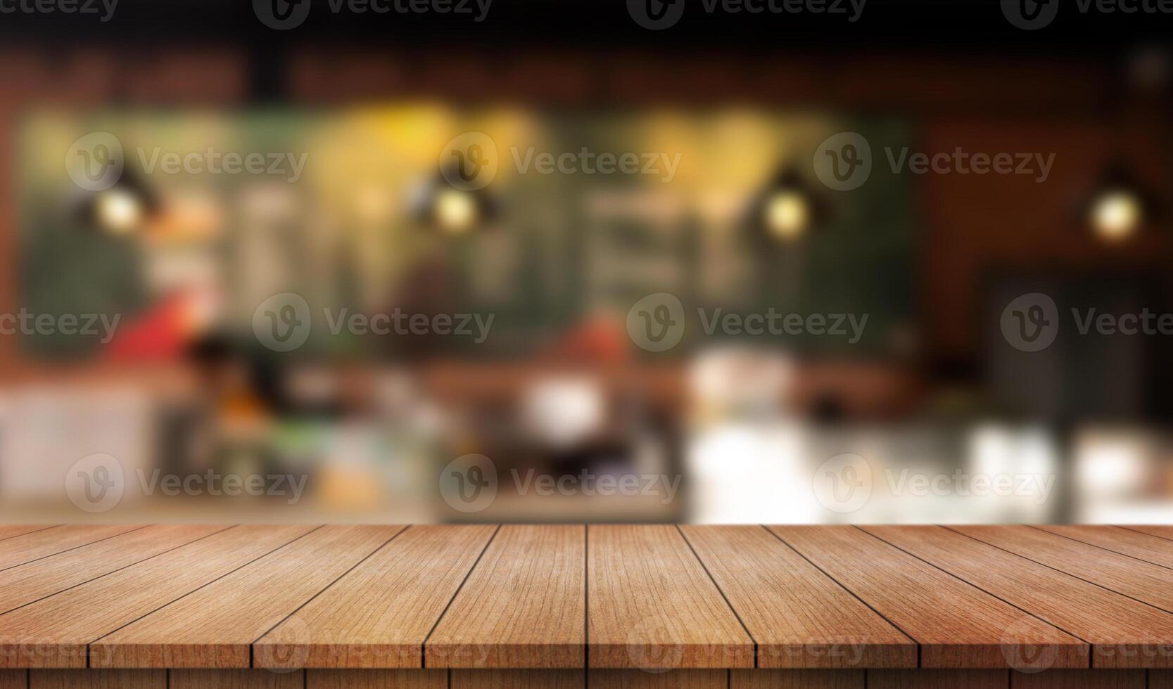 Empty wooden table top with lights bokeh on blur restaurant background photo