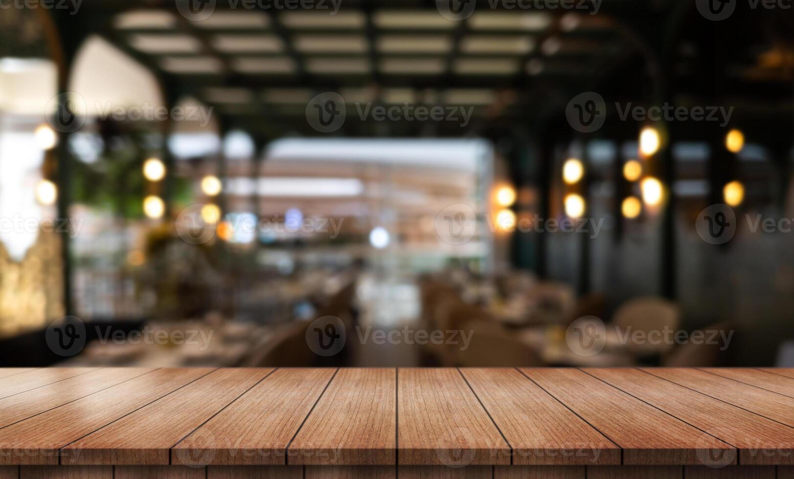 Empty wooden table top with lights bokeh on blur restaurant background photo