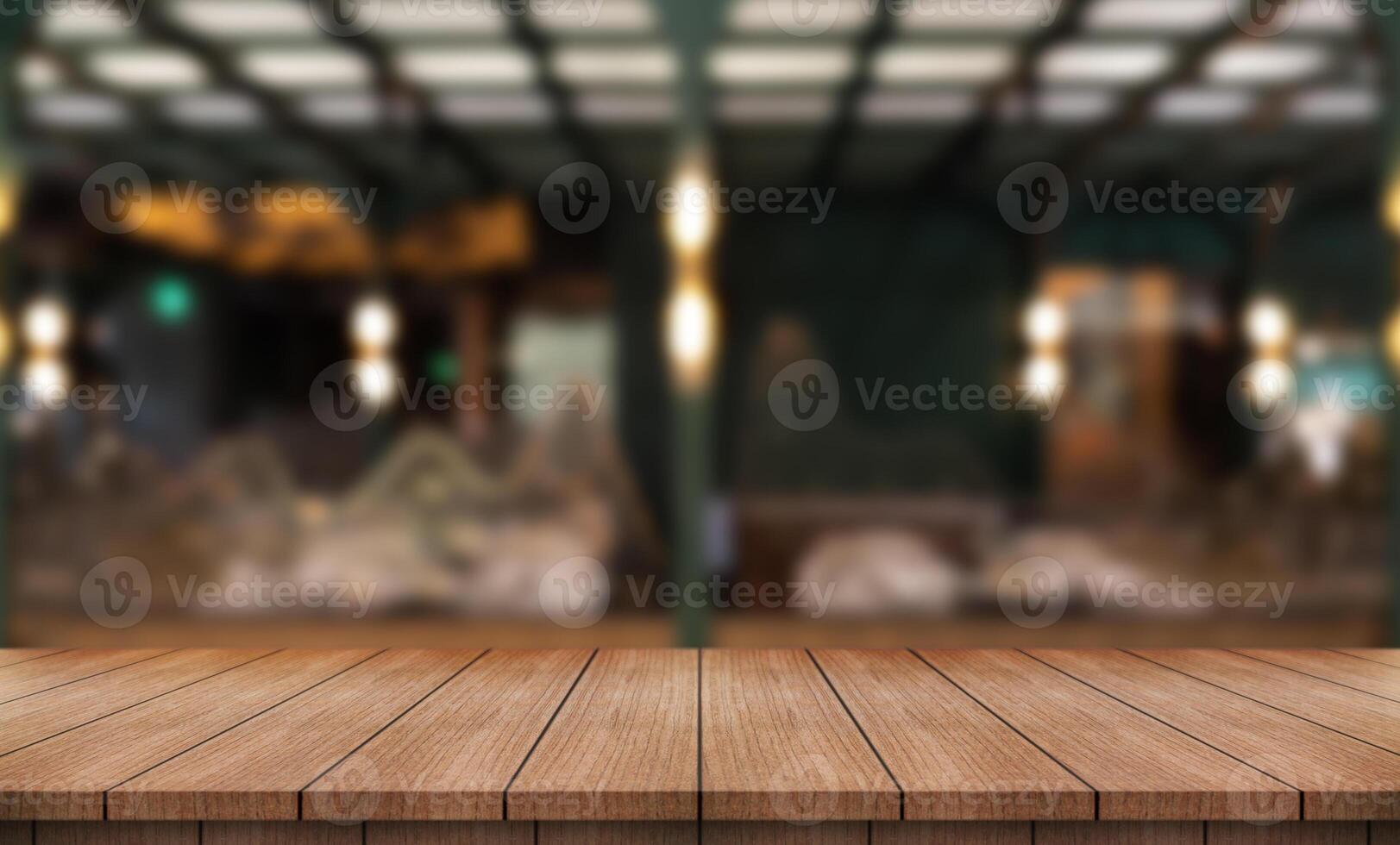 Empty wooden table top with lights bokeh on blur restaurant background photo