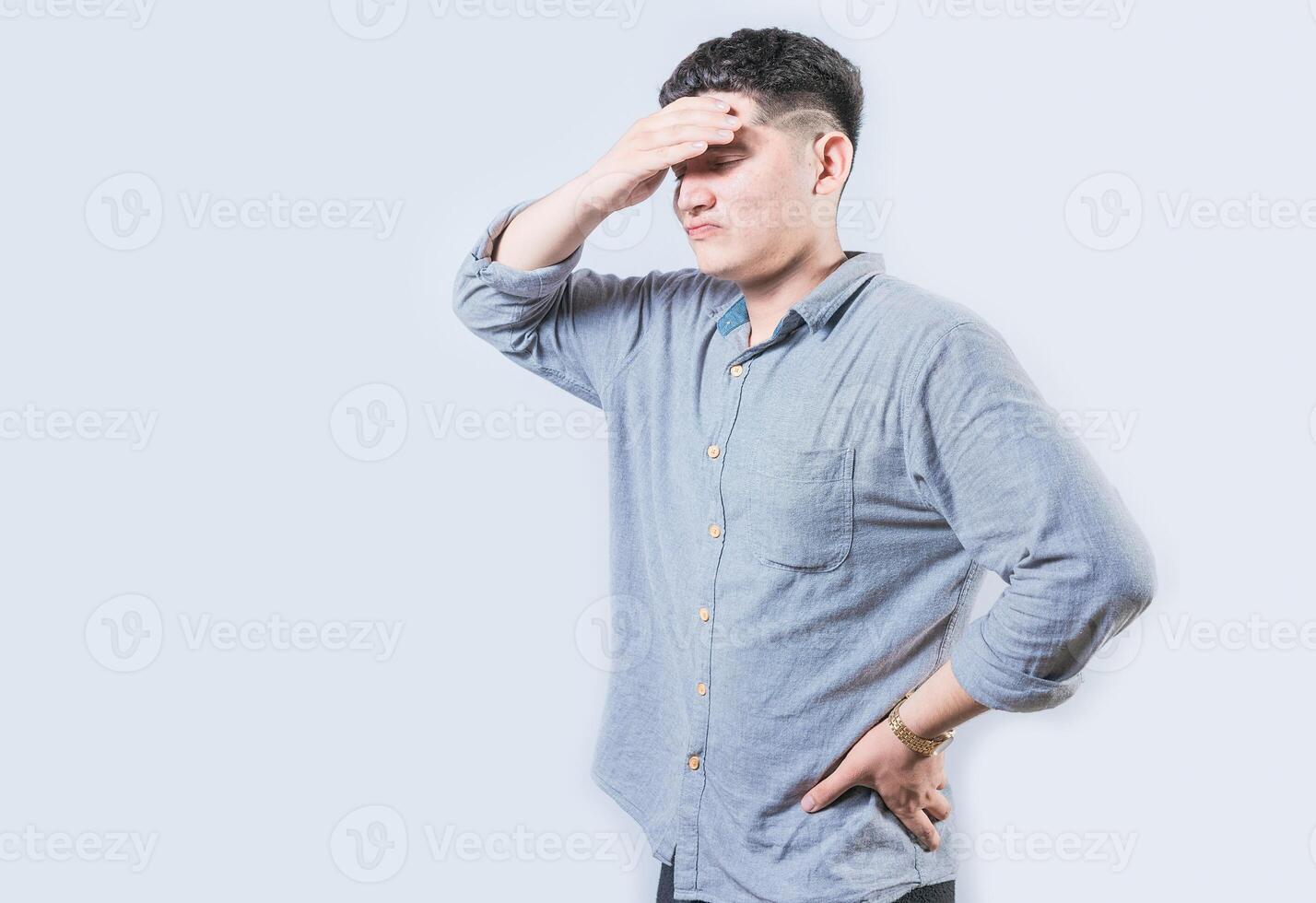 Tired man holding his head isolated. Worried young man holding his forehead isolated photo