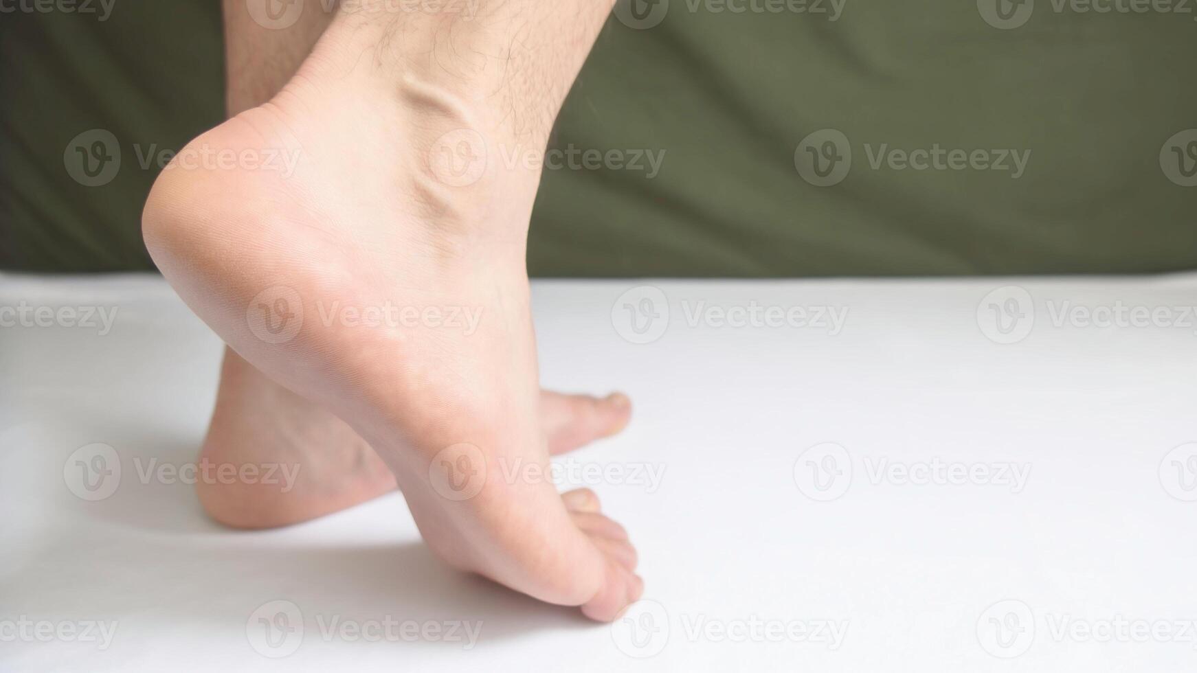 Male feet showing heel, ankle and arch of the sole of the foot. With space for text to the right. photo