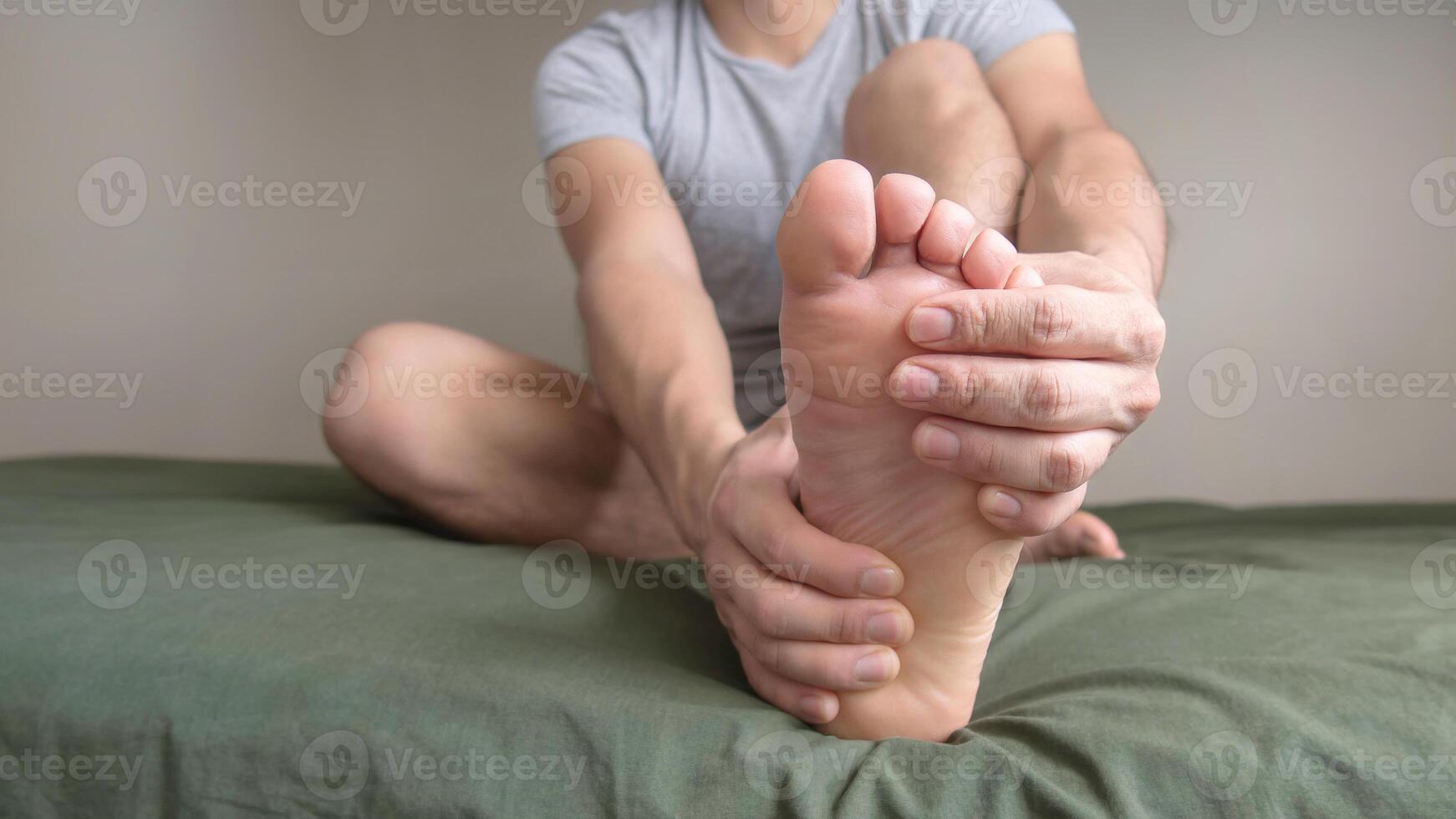 persona masajear su pie debido a dolor en el único, arco y dedos de los pies. espacio para texto en el izquierda. foto