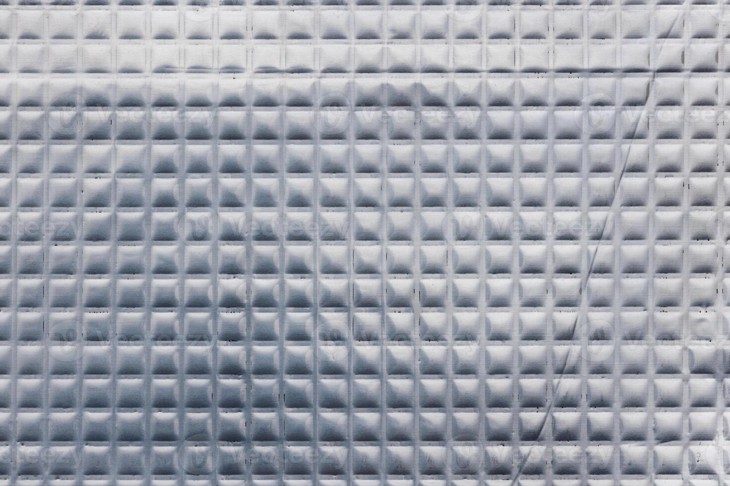 Closeup full-frame background and texture of aluminum coated butil rubber sheet with square pattern. photo