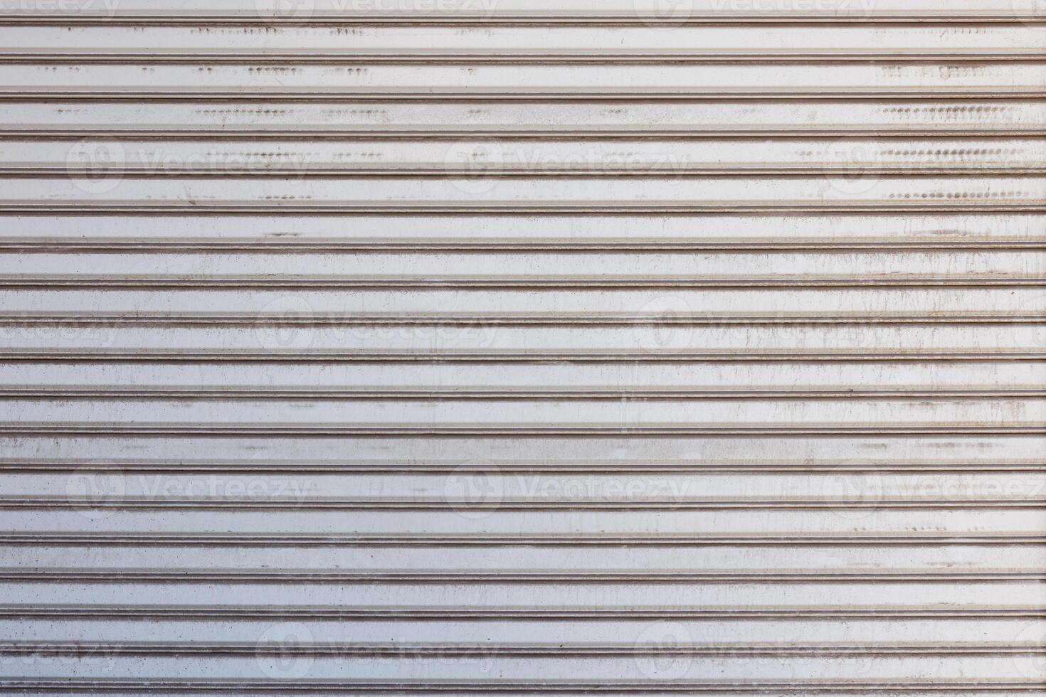 Closeup of a weathered metal shutter with horizontal folding lines photo