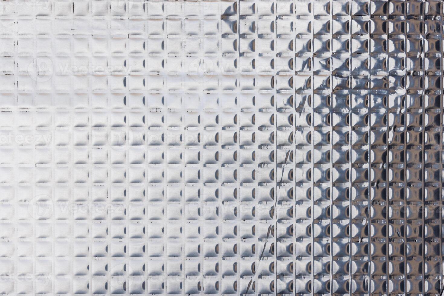 Closeup full-frame background and texture of aluminum coated butil rubber sheet with square pattern. photo