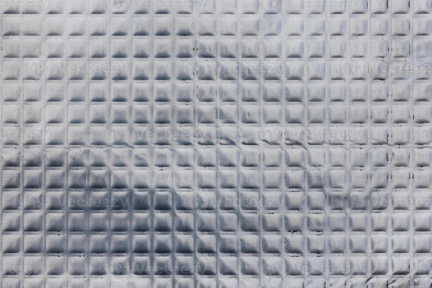 Closeup full-frame background and texture of aluminum coated butil rubber sheet with square pattern. photo