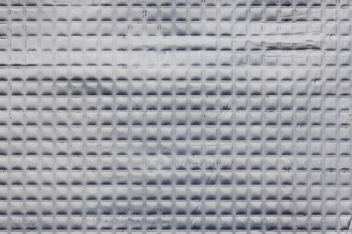 Closeup full-frame background and texture of aluminum coated butil rubber sheet with square pattern. photo