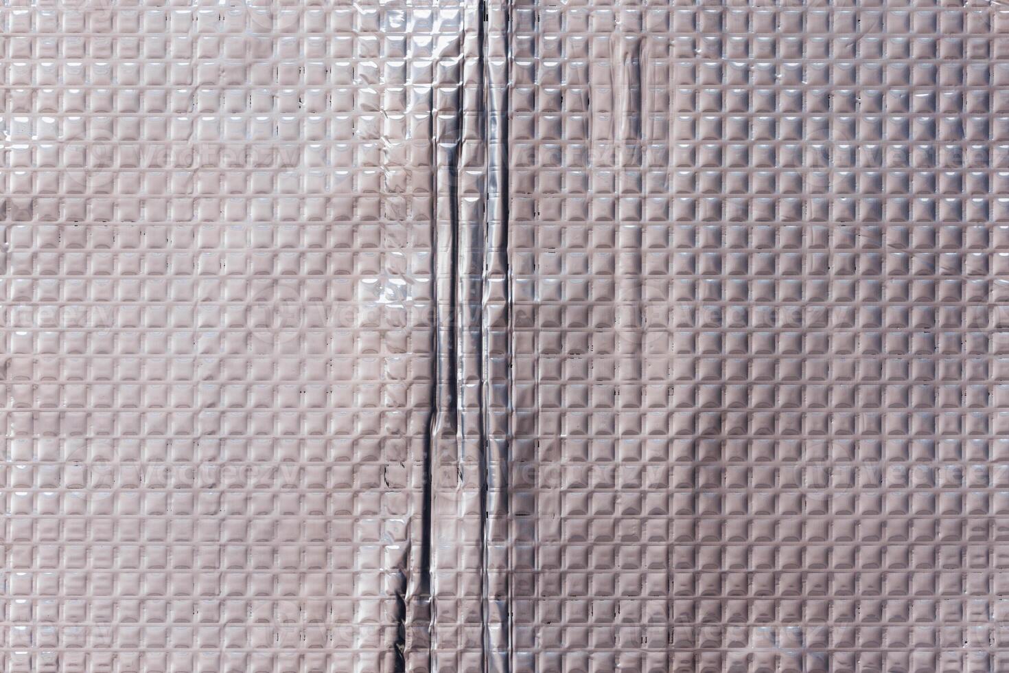 Closeup full-frame background and texture of aluminum coated butil rubber sheet with square pattern. photo