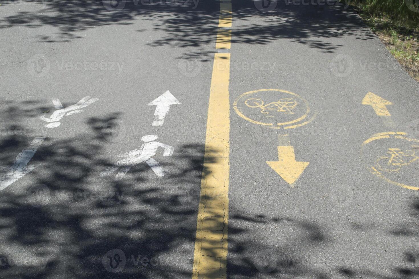 Road sign on asphalt with shadows of tree. photo