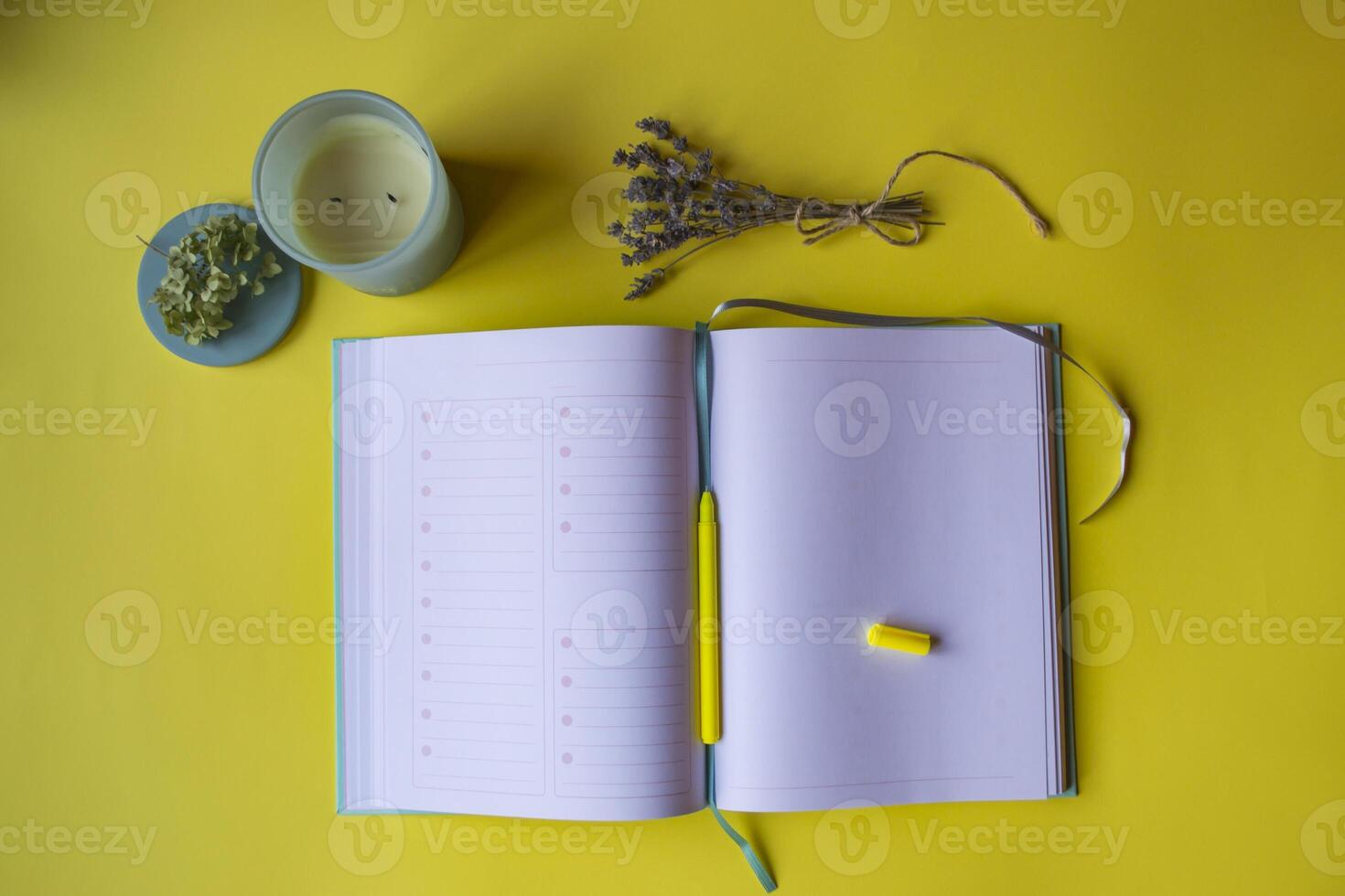 Opened planner with decor on a yellow background. Modern workplace. photo