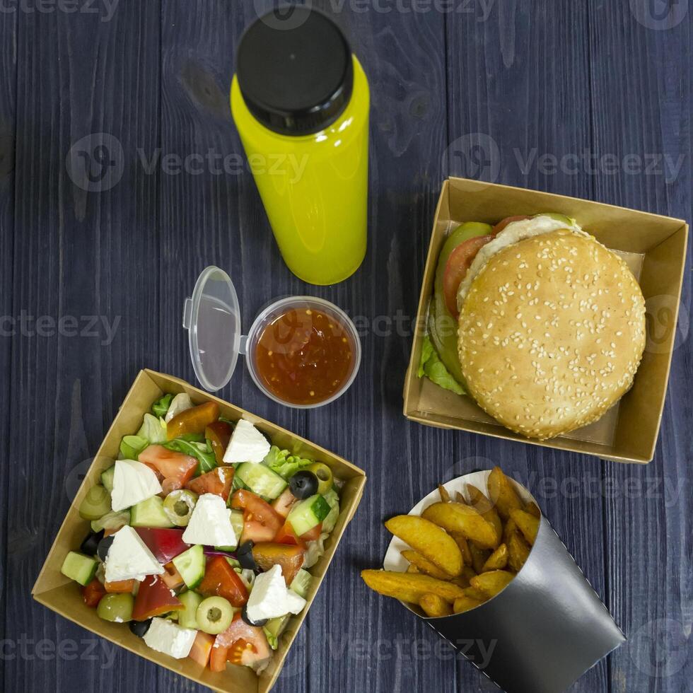 Buger salad french fries with sauce and juice on the table. Fast food table photo