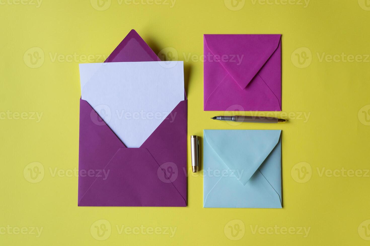 The colorful envelopes with note blank on the yellow background. Background with copy space. photo