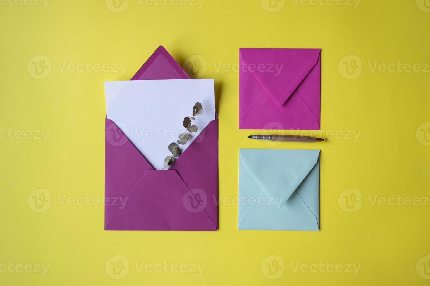 The colorful envelopes with note blank on the yellow background. Background with copy space. photo