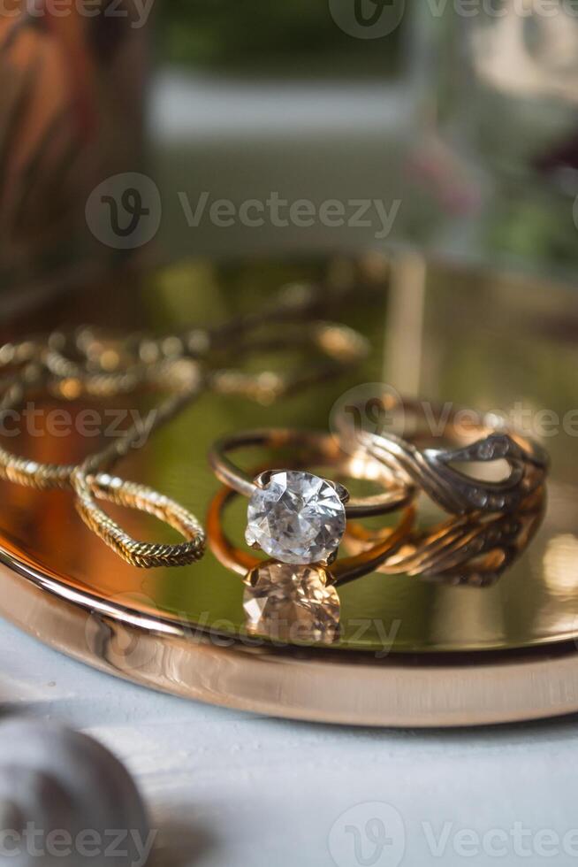 Golden ring with diamonds. Female jewelry on a table, close up. photo