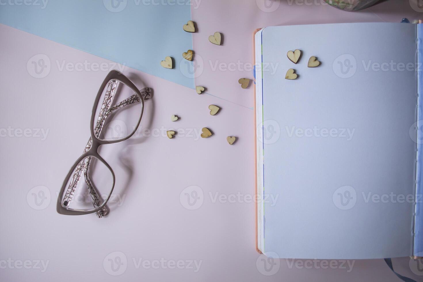 Eye glasses and opened notebook on a table. photo