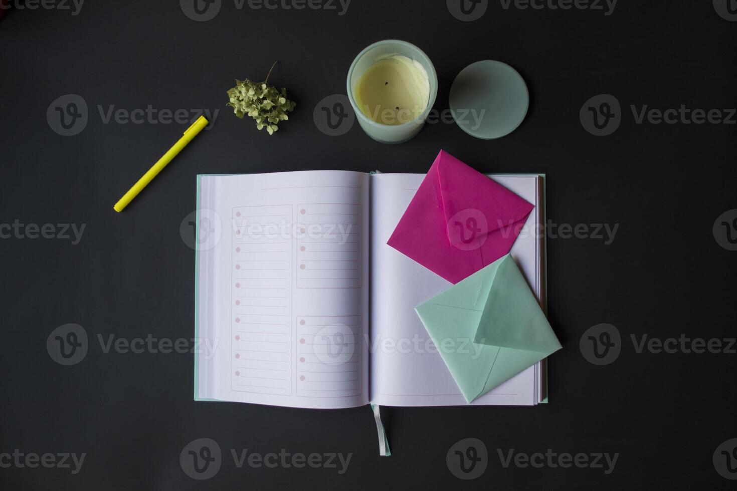 The turquoise and pink colors envelopes on the opened notepad, close up. photo