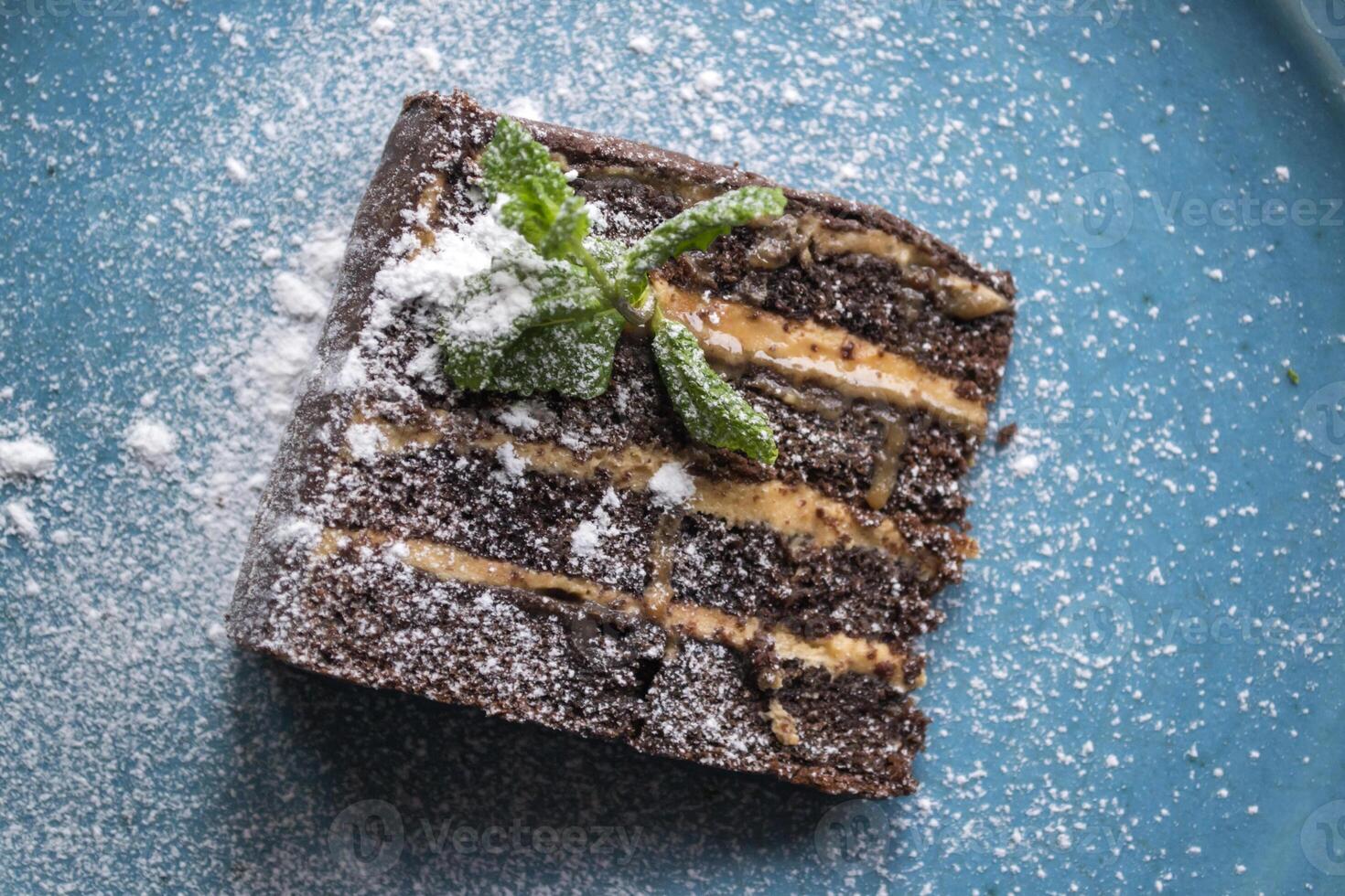 The brownie in a plate on a blue table. photo