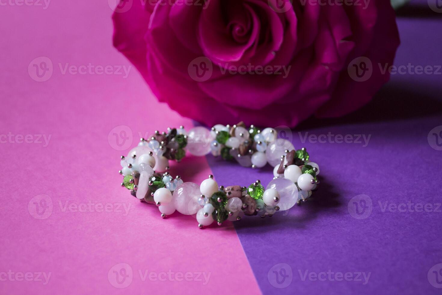 The hand bracelet with decor on pink background. photo