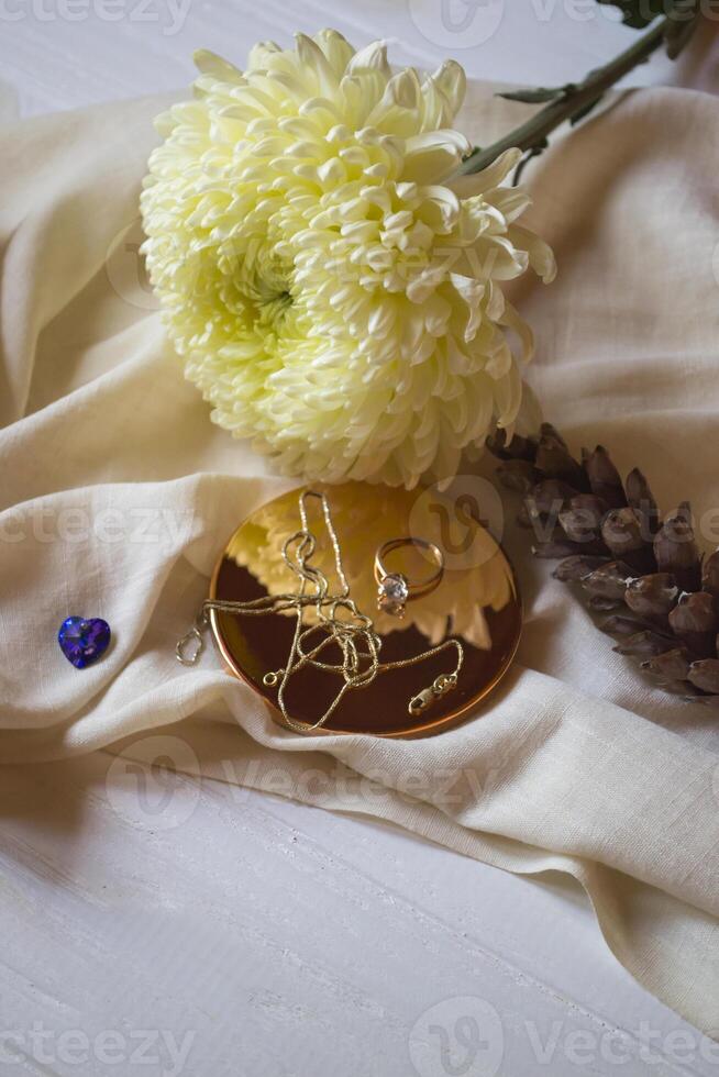 The golden chain and ring with diamond near flower, close up. photo