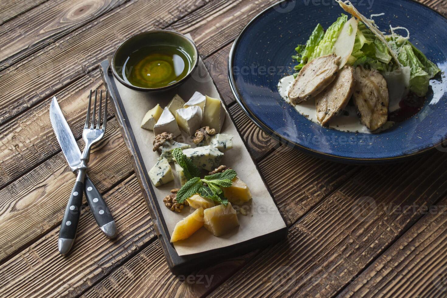 The hot salad with meat, and cheese plate on a wooden table. photo
