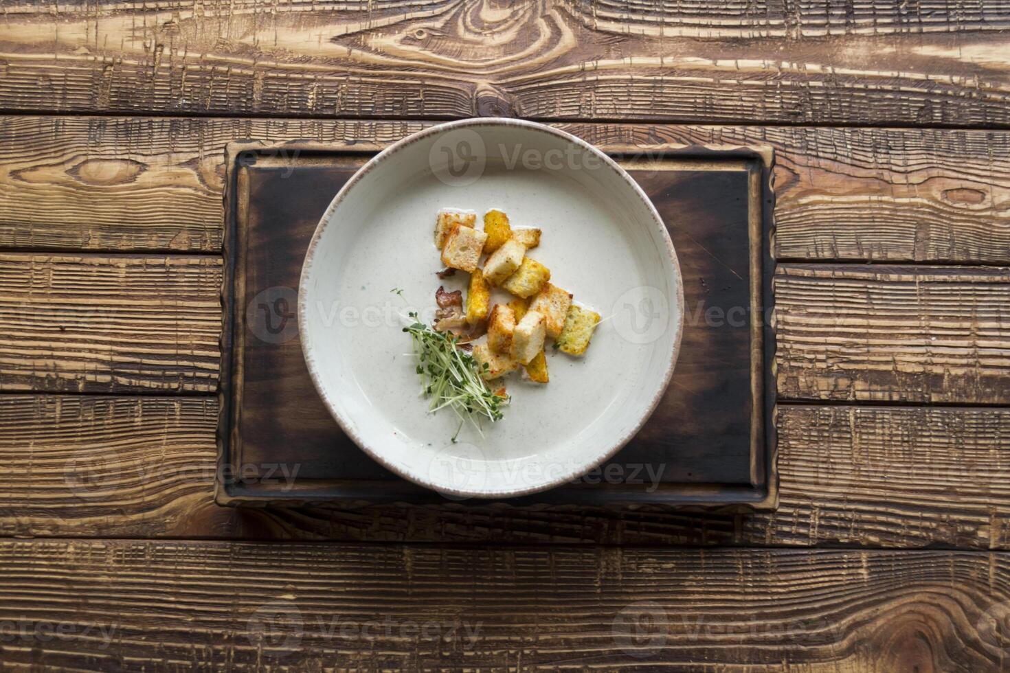 Cream soup in a plate, on a wooden table. photo